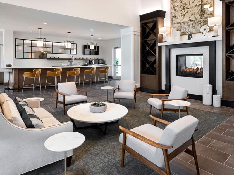 communal area with a counter, couch, chairs around a table in front of a fireplace