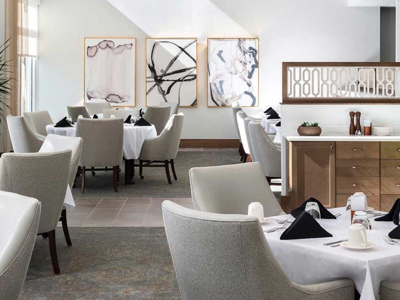 dining area at amavida, showing triptych artwork on wall and set tables