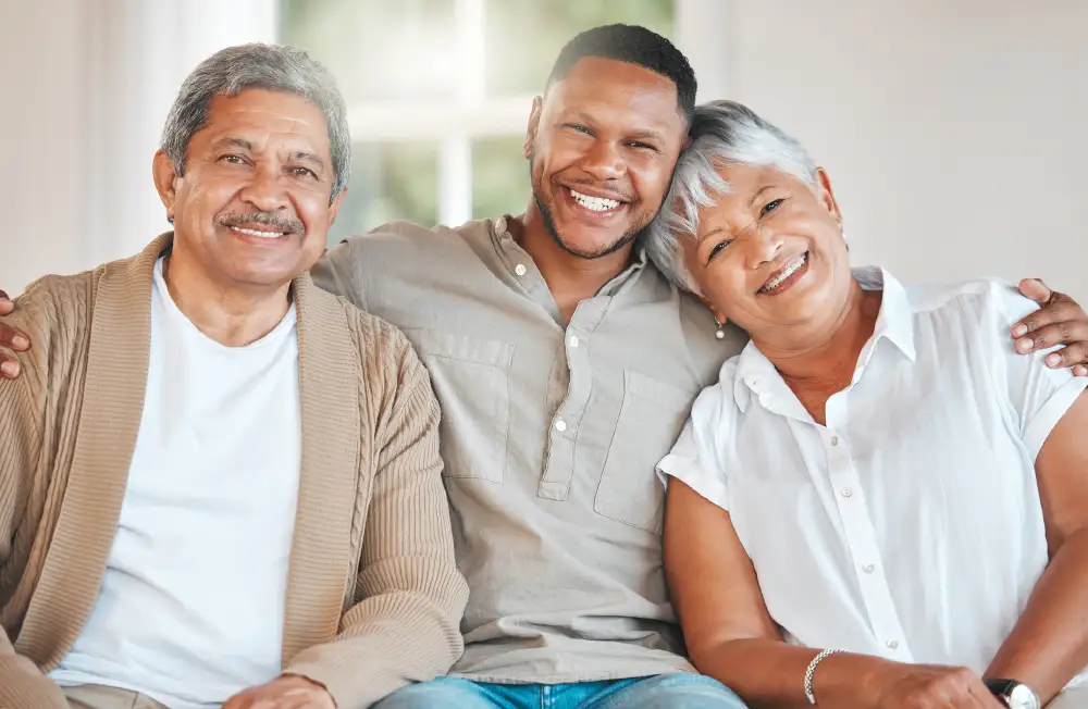 a man with his arms around his senior parents with dementia
