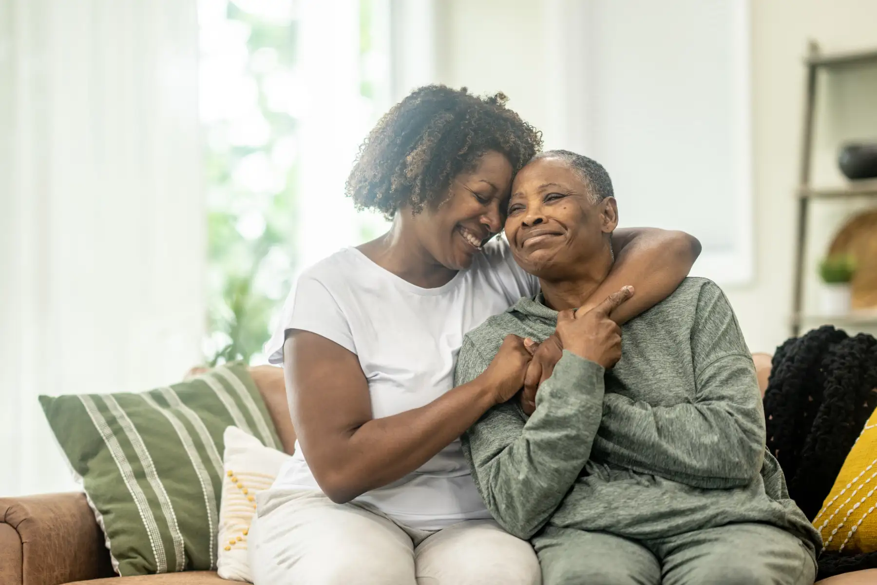 a woman with her arms lovingly around her senior mother with dementia